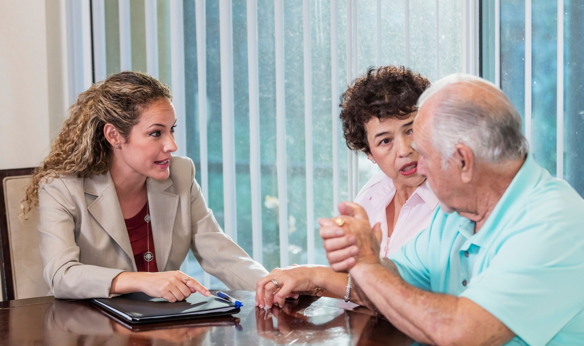 Senior Hispanic couple at home with financial advisor